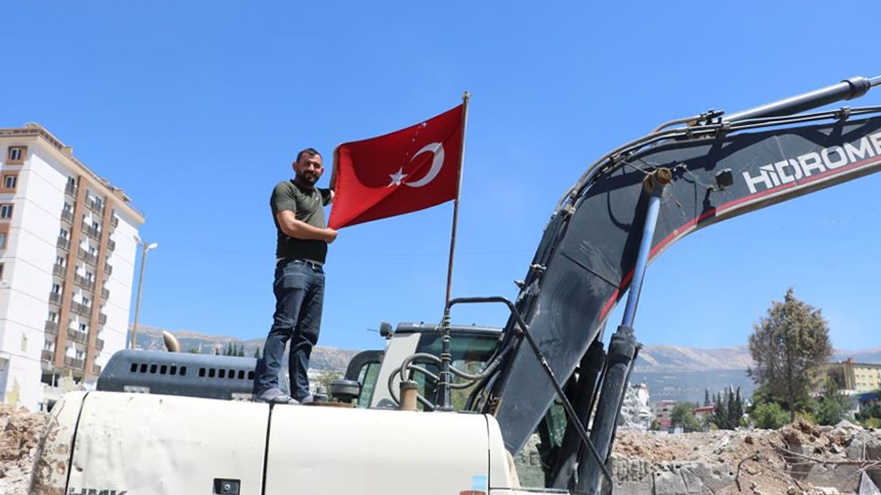 Kahramanmaraş'ta enkazdan çıkardığı Türk bayrağını iş makinesinde dalgalandırıyor