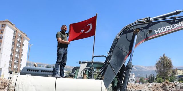 Kahramanmaraş'ta enkazdan çıkardığı Türk bayrağını iş makinesinde dalgalandırıyor