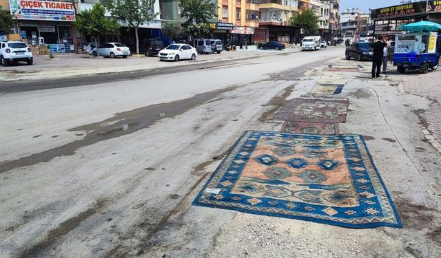 Belediyenin yapmadığı yola esnaftan ilginç çözüm: Yola asfalt yerine halı serildi
